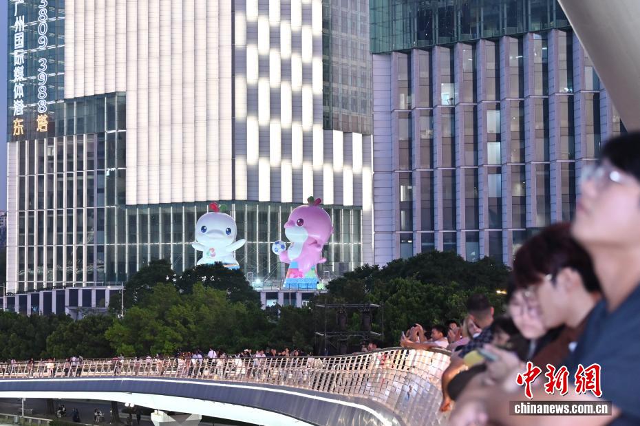 広州市海珠区広州タワー財富埠頭で、第15回全国運動会・スペシャルオリンピック全国大会の公式マスコット「喜洋洋」と記念写真を撮影する観光客(10月26日撮影・陳楚紅)。