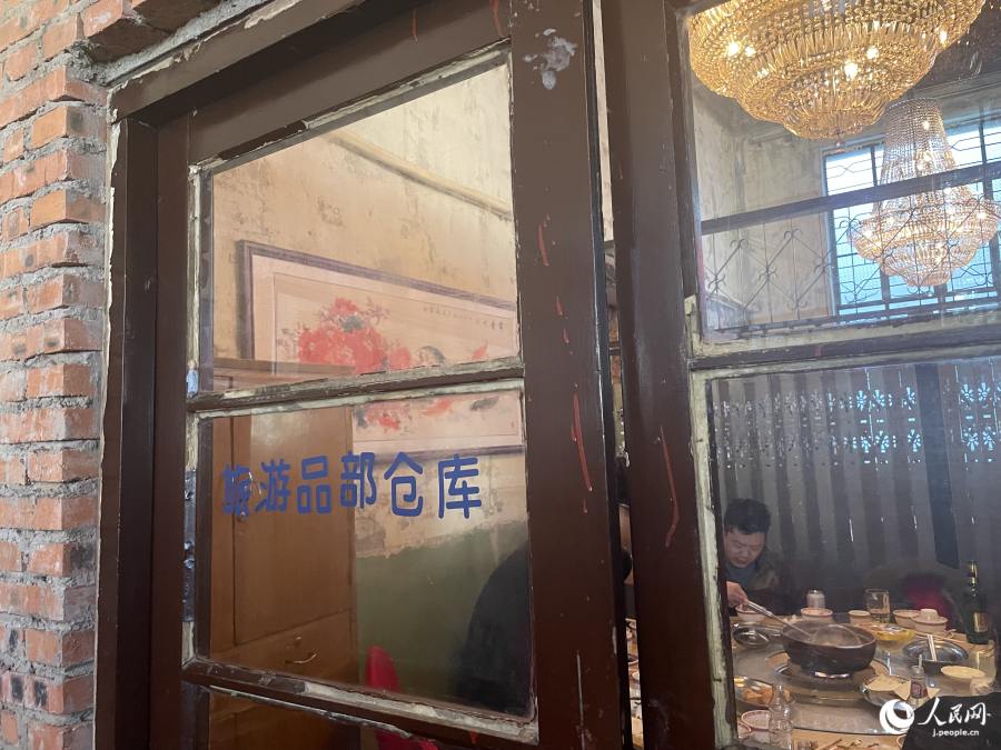 「旅遊品部倉庫」と書かれたガラス扉。「旅遊」は旅行・観光という意味(撮影・勝又あや子)