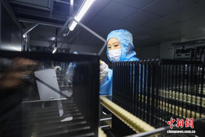 タブレット用タッチスクリーンカバーガラスの完成品を検査する検査員(撮影・瞿宏倫)。