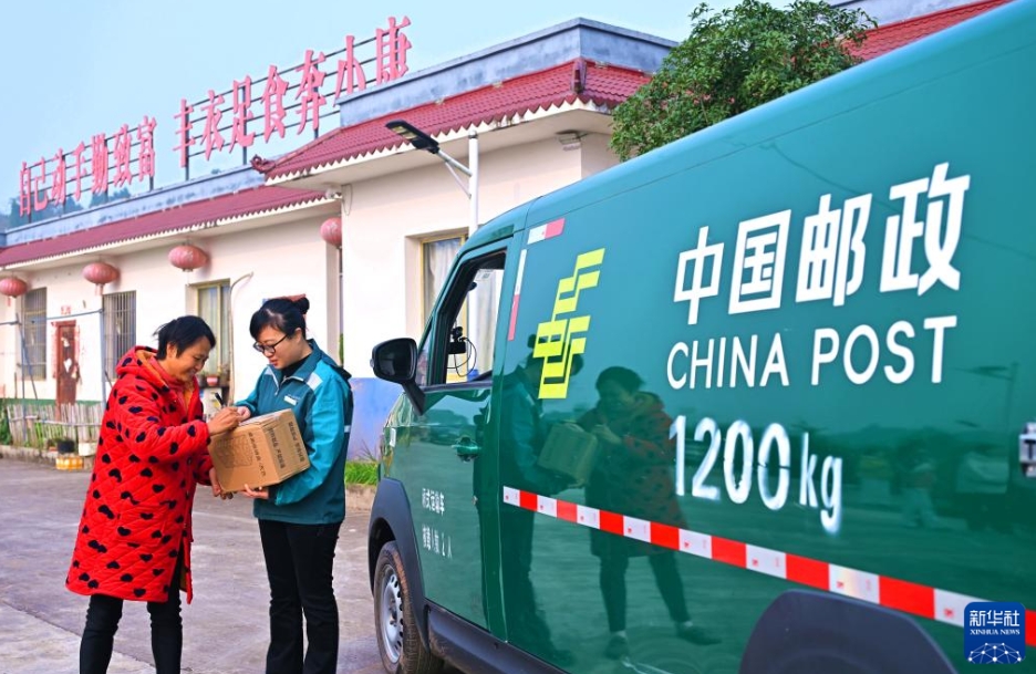 四川省眉山市仁寿県珠嘉鎮三渓社区(コミュニティ)で、住宅まで荷物を配達する宅配員(12月1日撮影・潘帥)。