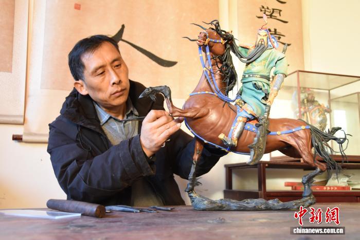 面塑作品「関羽騎馬」を制作する、陳氏面塑の五代目伝承者・陳道勇さん（撮影・王宇）。