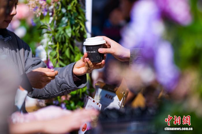 屋台で購入したコーヒーを受け取る市民（撮影・侯宇）。