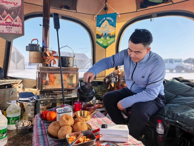 テントの中でお茶を飲む吉林省のキャンパー・王凱さん（撮影・張玥）。