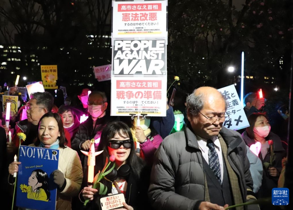 東京の国会議事堂前で、スローガンを手に抗議集会に参加する人々（3月10日撮影・李子越）。