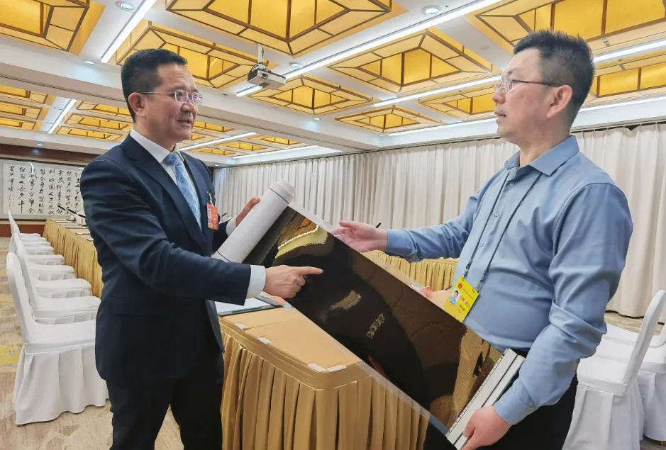 フレキシブルペロブスカイト太陽電池について説明する侯景濱代表（左）。撮影・張蘊