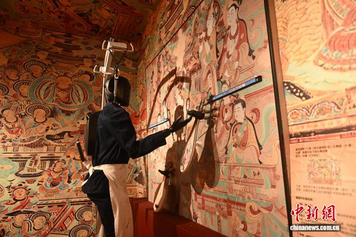 甘粛省蘭州市城関区のモバイルロボットアートトイランドで、壁画の修復のデモンストレーションを行うロボット（2月23日撮影・李亜龍）。