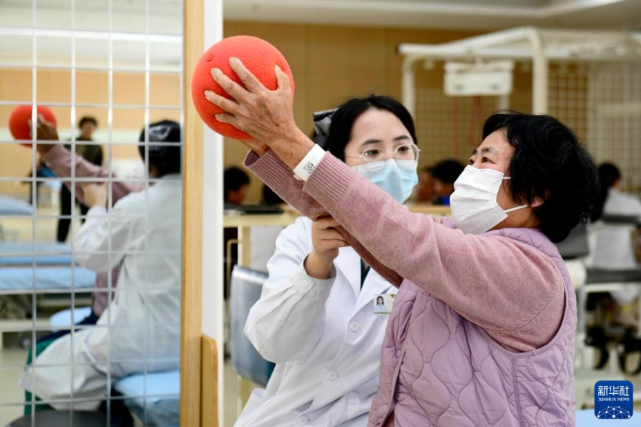 日照市リハビリテーション病院で、高齢者のリハビリ訓練をサポートする医療関係者（3月25日撮影・郭緒雷）。