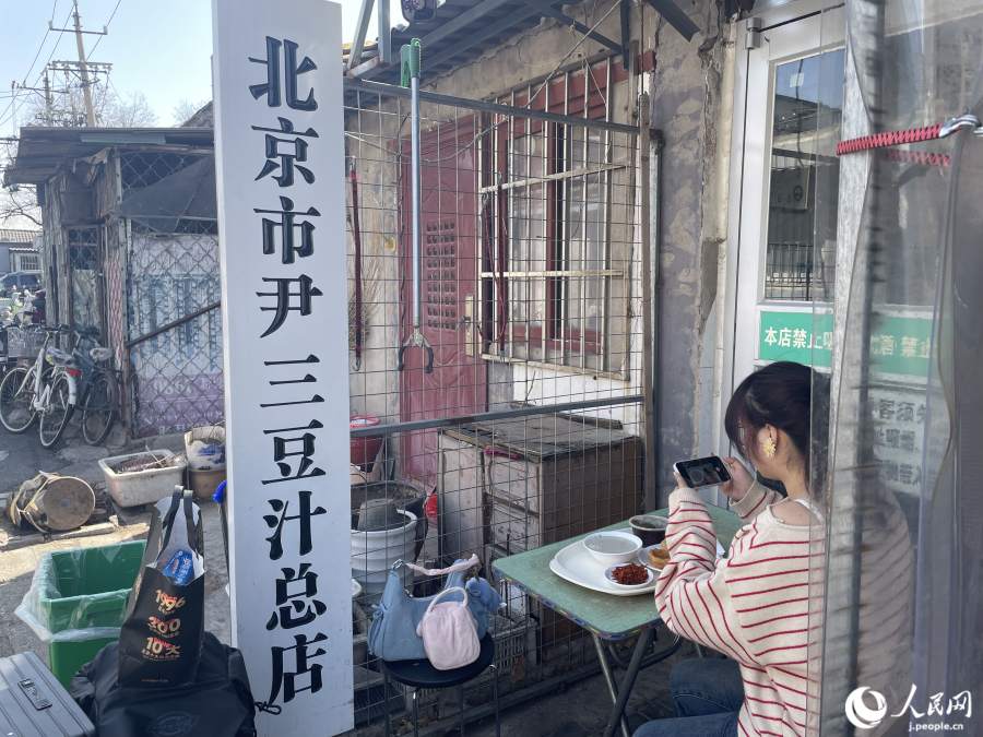 尹三豆汁店の店先で写真撮影に余念のない観光客。（撮影・勝又あや子）