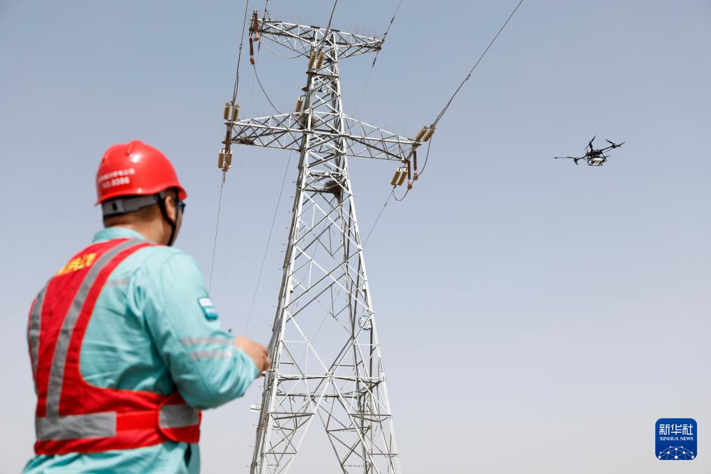 4月23日、大型マルチロータードローンを操作し、110キロボルト沙永線70号鉄塔の磁器製がいし装置の洗浄作業を行っている国網銀川電力供給公司送電運用検査センターの作業員。