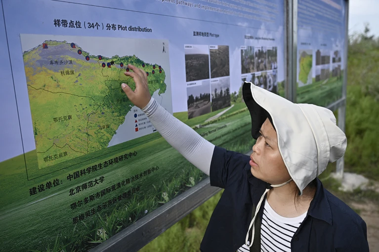 庫布其（クブチ）砂漠で活動する学生。庫布其砂漠は中国の内蒙古（内モンゴル）自治区における「緑の長城」プロジェクトの一部だ。（写真出典：英誌「ネイチャー」ウェブサイト）