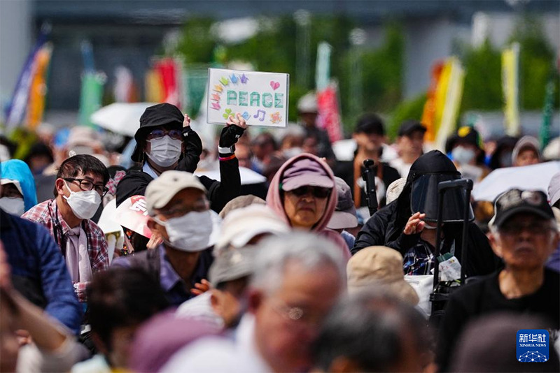 5月3日、日本・東京都江東区有明にある東京臨海広域防災公園で、手持ちバナーを持って集会に参加した人々。（撮影・賈浩成）