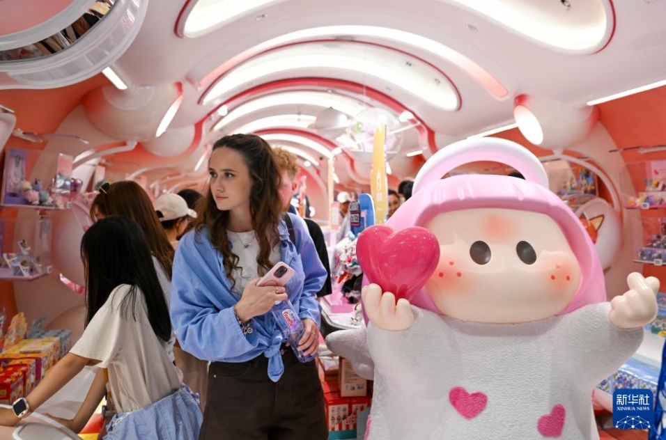 上海の南京路歩行者天国にあるアートトイショップで、商品を選ぶ外国人観光客（5月5日撮影・陳浩明）。