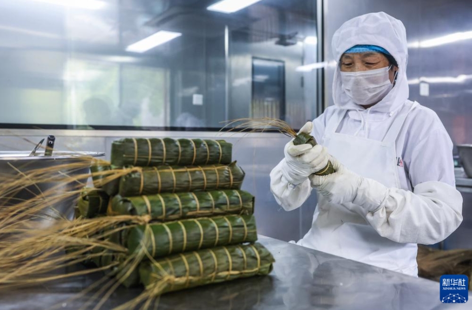 麗水市遂昌県三仁畲族郷高碧街村の浙江遂昌原食農業共富工坊の作業場で「遂昌長粽」を作る「遂昌長粽」の無形文化遺産技芸代表性伝承人の張冬梅さん（5月7日撮影・徐昱）。