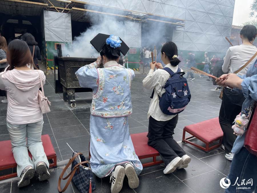 雍和宮でお線香を供え、熱心に祈る漢服姿の参拝客（撮影・勝又あや子）