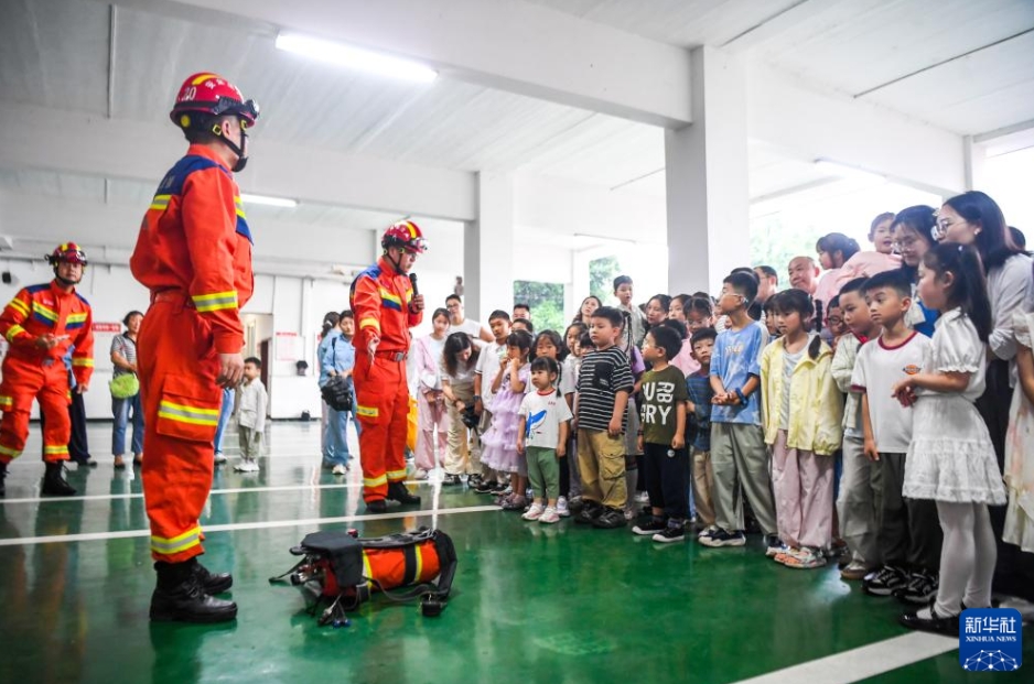中国石化川維化工消防支隊の営舎で、児童たちに消防装備や機材を紹介する消防隊員（6月1日撮影・唐奕）。
