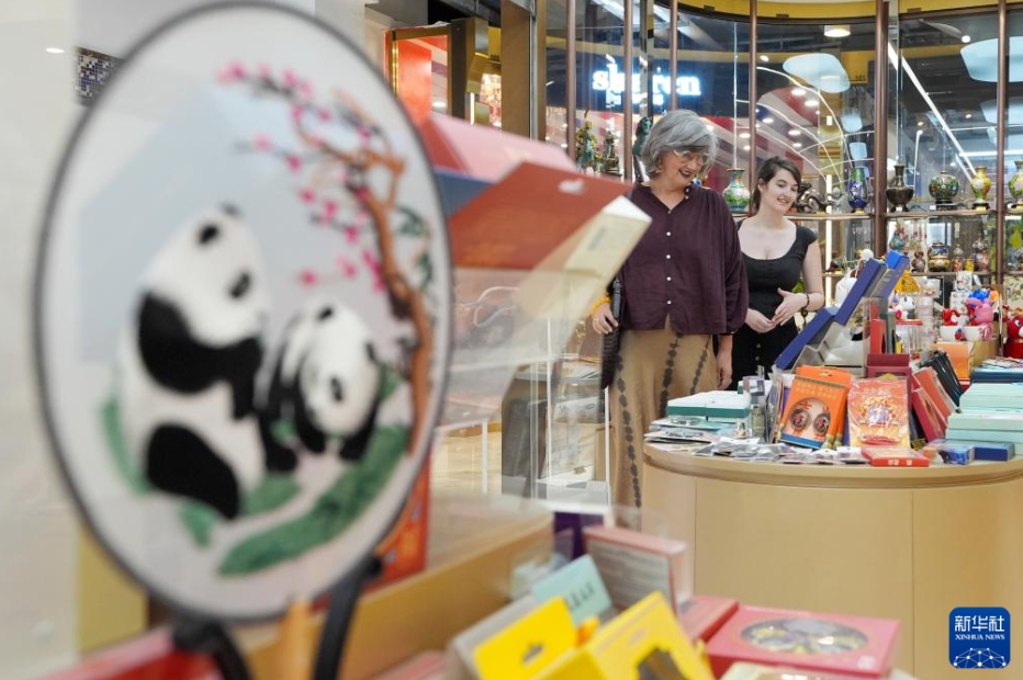 北京のショッピングエリア・秀水街の店で土産を選ぶオランダ人観光客（6月1日撮影・鞠煥宗）。
