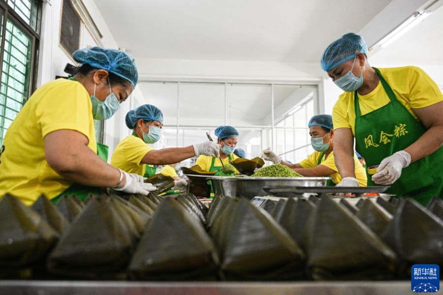 海南省文昌市にある鳳会糯米花工場で、鳳会粽を包む作業員（6月12日撮影・蒲暁旭）。