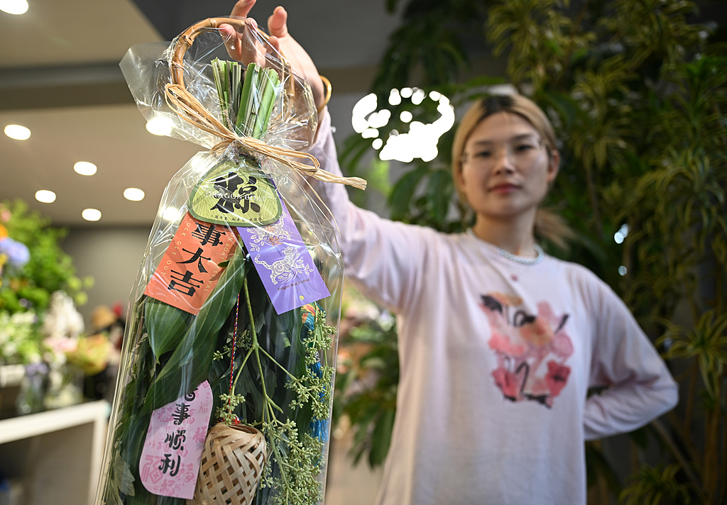 6月16日、杭州市で購入したヨモギ飾りを見せる女性。（写真著作権はCFP視覚中国所有のため転載禁止）。