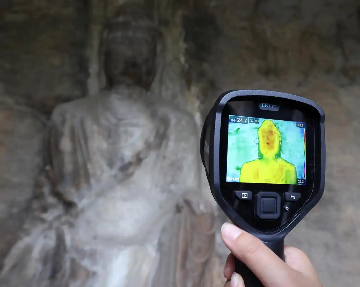 2026年5月12日、竜門石窟研究院石窟保護研究・文化遺産モニタリングチームの劉睿氏が、極南洞で赤外線サーモグラフィーカメラを用いて漏水箇所を確認する様子（撮影・李嘉南）。