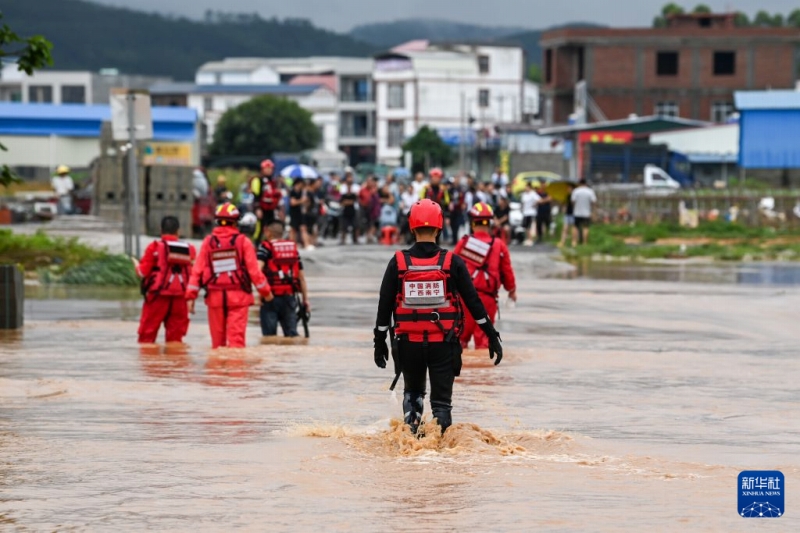 7月6日、広西・南寧横州市校椅鎮の冠水した道路を歩く救助隊員（撮影・曹禕銘）。