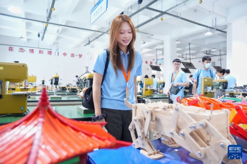 7月4日、華中テクノロジー大学工学訓練・イノベーションセンターで、学生が制作した作品を見学する台湾の若者（撮影・馬欣然）。