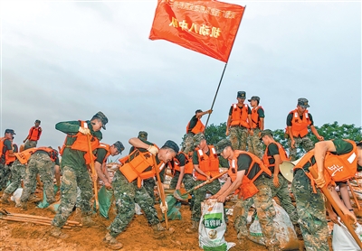 7月7日、武警広西総隊機動支隊は将兵500人を広西貴港市港北区の被災地に派遣。写真は堰や堤防を強化する将兵たち（撮影・劉明、写真提供：影像中国）。