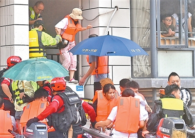 7月8日、広西貴港市西江教育パークで身動きが取れなくなっていた教師や学生を救助する救助隊員（撮影・周華）。