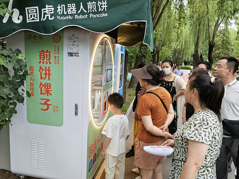 北京の青年湖公園に登場し、来園者の注目を集めている中国風クレープ調理AIロボット（7月14日撮影・写真著作権はCFP視覚中国が所有のため転載禁止）