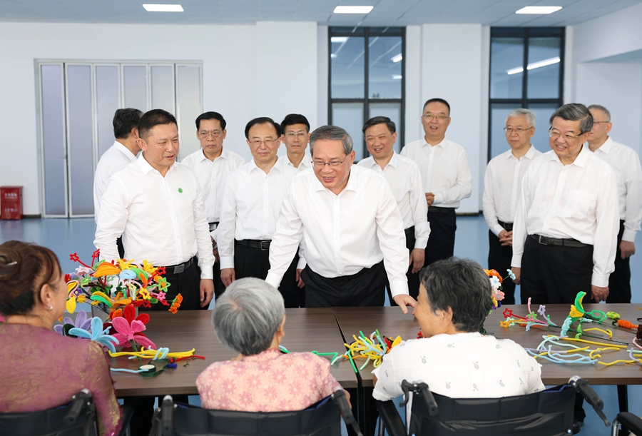 28日、唐山市対麻痺療養院で、地震により下半身不随となった負傷者を見舞い、親しく言葉を交わす李強総理（撮影・黄敬文）