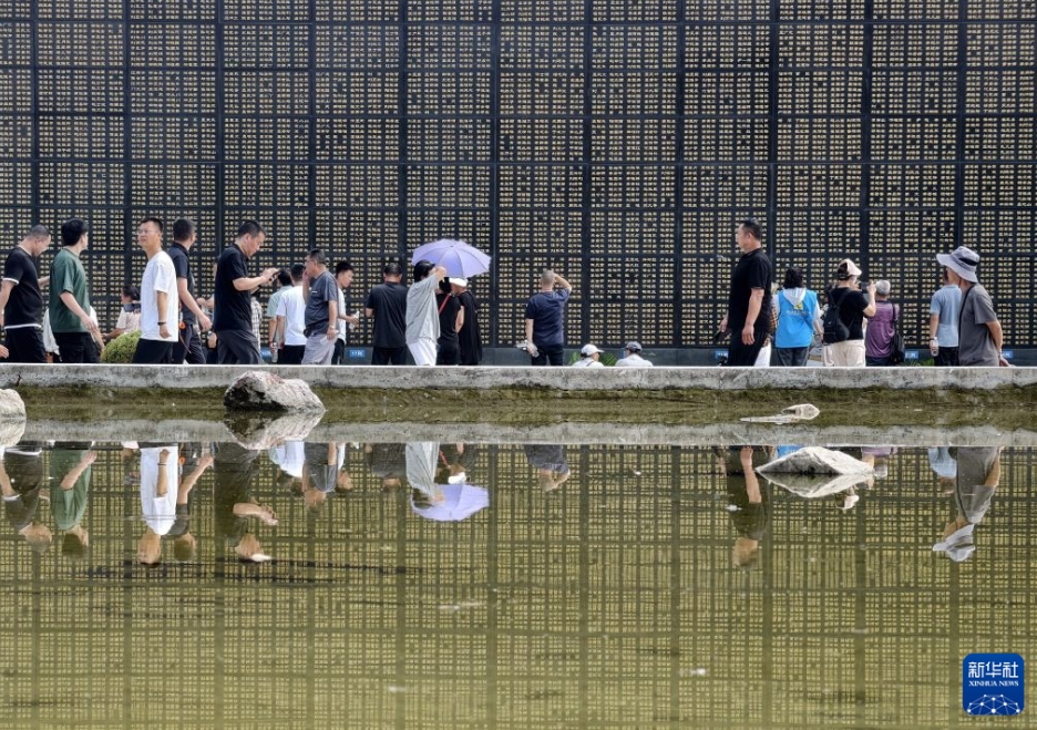 唐山地震から50年、犠牲者の名前が刻まれた石壁の前で人々が追悼