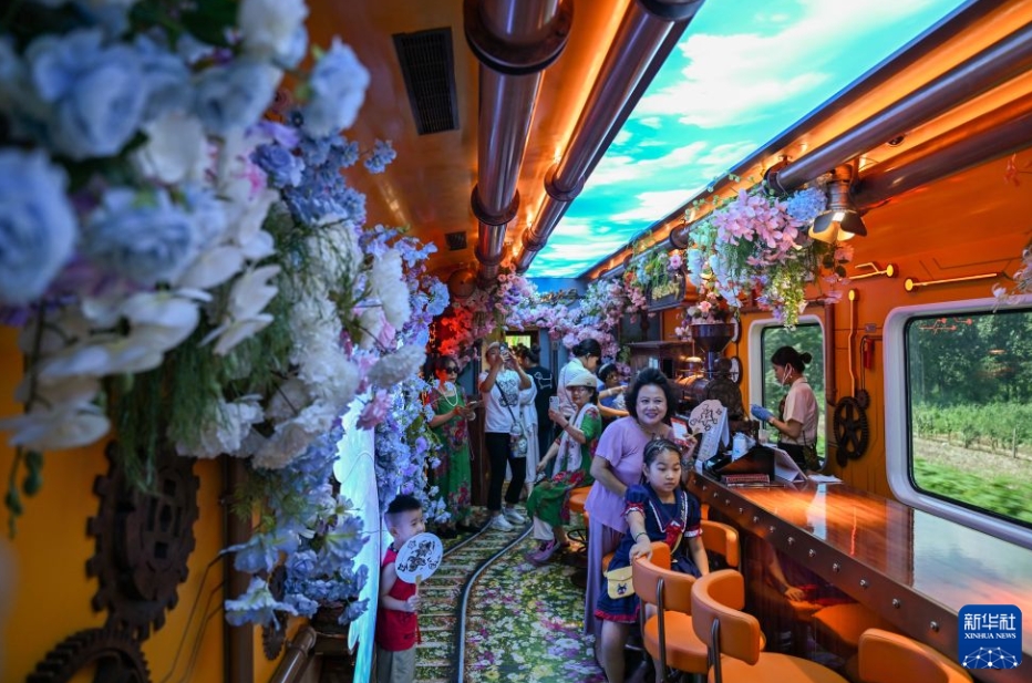 「津旅時光号」のスチームパンク・ファンタジーガーデン車両内で、写真を撮影する乗客（7月29日撮影・孫凡越）。