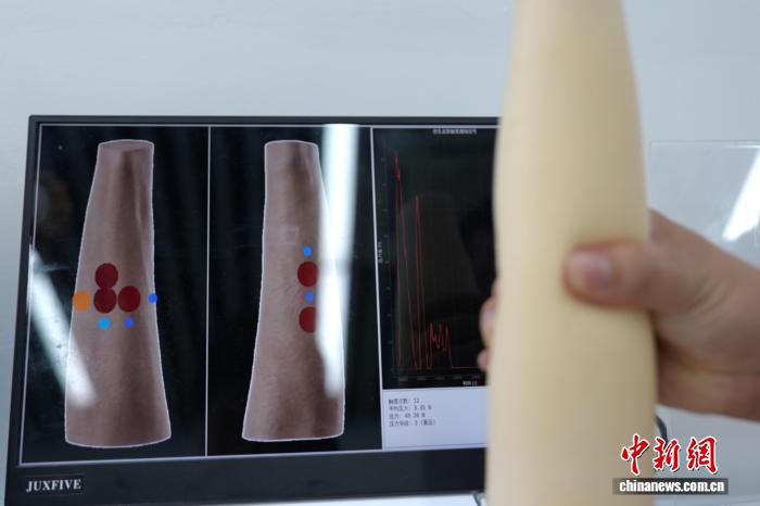 8月4日、研究者がフレキシブル電子皮膚の圧力感知機能を実演。撮影・張俊