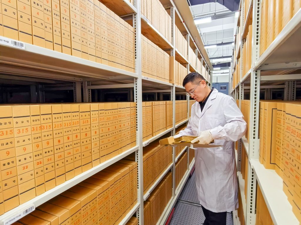 9月17日、移動式書架から取り出した史料を確認する吉林省公文書館の職員。（撮影・王帆）