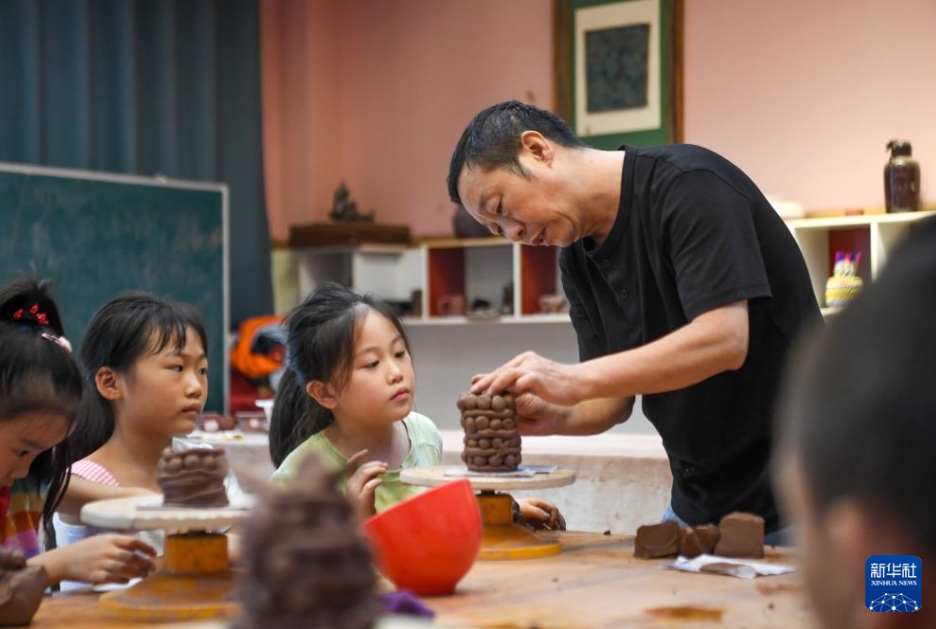 「陶韻」の特別授業で、教員の指導のもと、陶芸制作を体験する児童（9月22日撮影・唐奕）。
