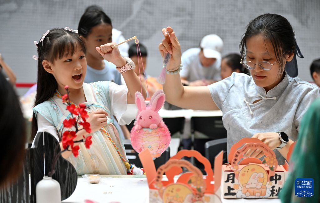 9月25日、海南省文化館で行われた中秋節の遊園イベントで、灯篭づくりに挑戦する親子（撮影・郭程）。