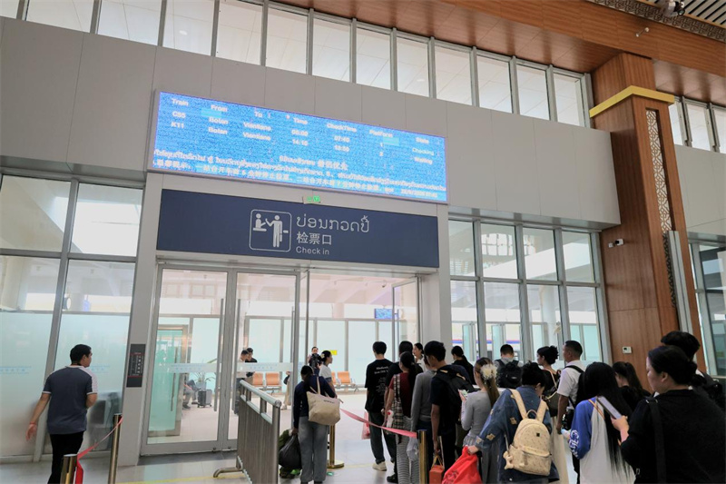 ボーテン駅の改札口で列に並び乗車を待つ乗客（中国ラオス鉄道有限公司提供）。