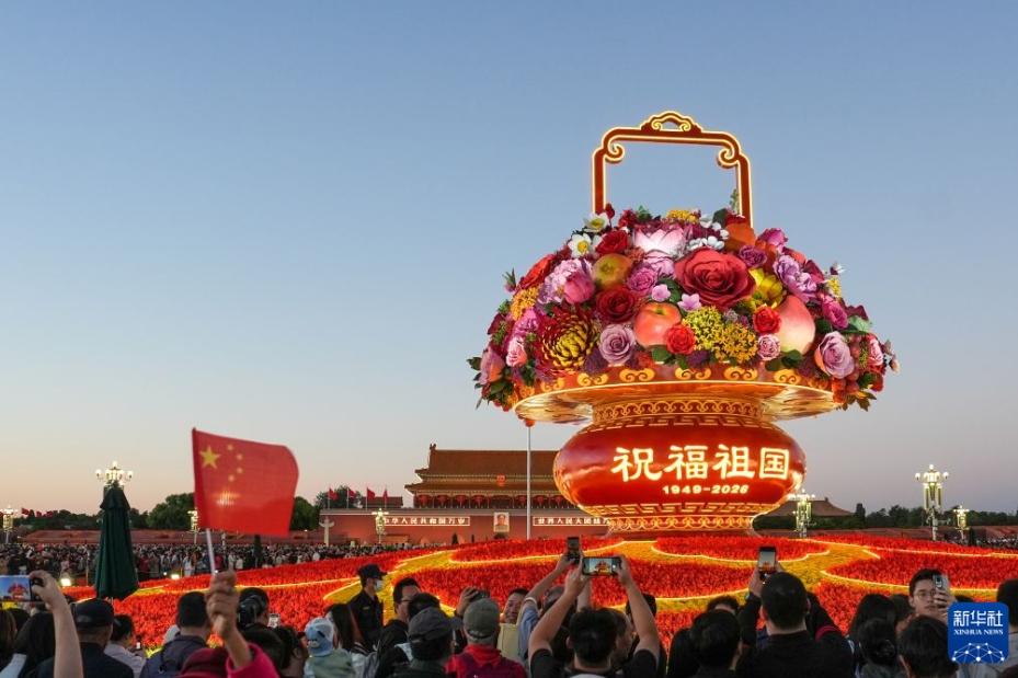 北京の天安門広場で、「祖国を祝福」をテーマとする巨大な花かご型のオブジェを撮影する観光客ら。（10月1日撮影・鞠煥宗）