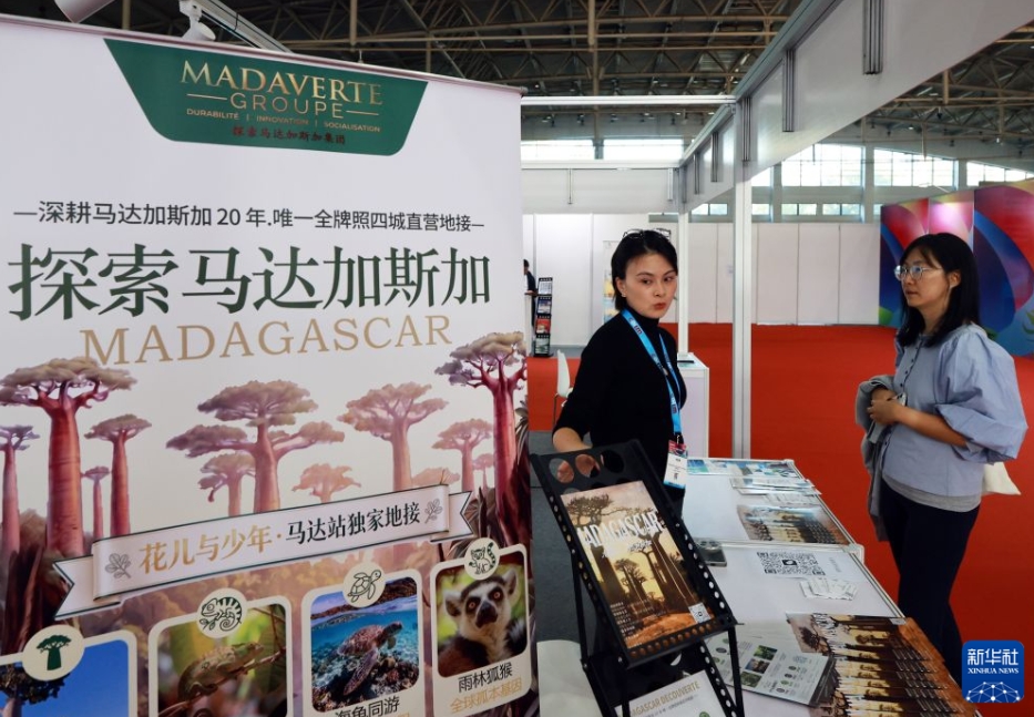 マダガスカルのブースで、観光プロジェクトを来場者に紹介する出展者（撮影・潘旭）。