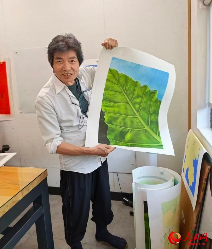 新作の「緑シリーズ」の一枚目を見せる園山氏（撮影・王暁霞）。