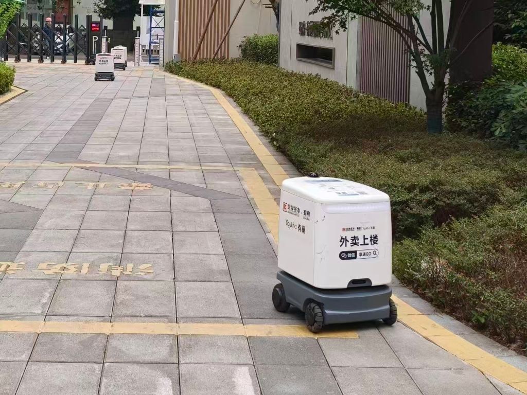 成都の住宅団地内で商品を配達する配送ロボット。