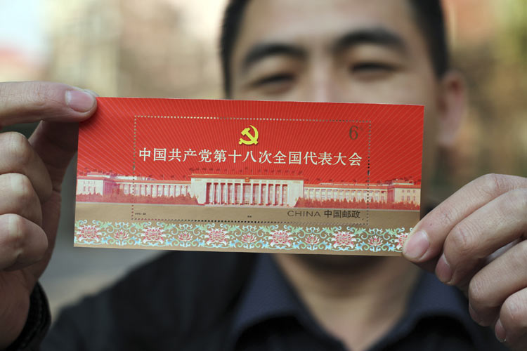 記念小型シートを見せる河北省邯鄲市の郵便局職員