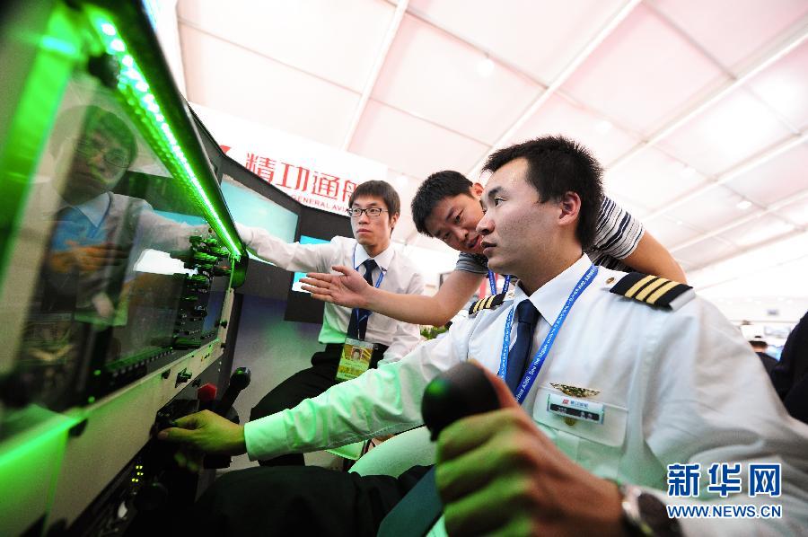 珠海で開催中の第9回中国国際航空航天（宇宙）博覧会で、精功通航のブースに設置されたシミュレーターで個人用飛行機の操縦について理解する来場者。