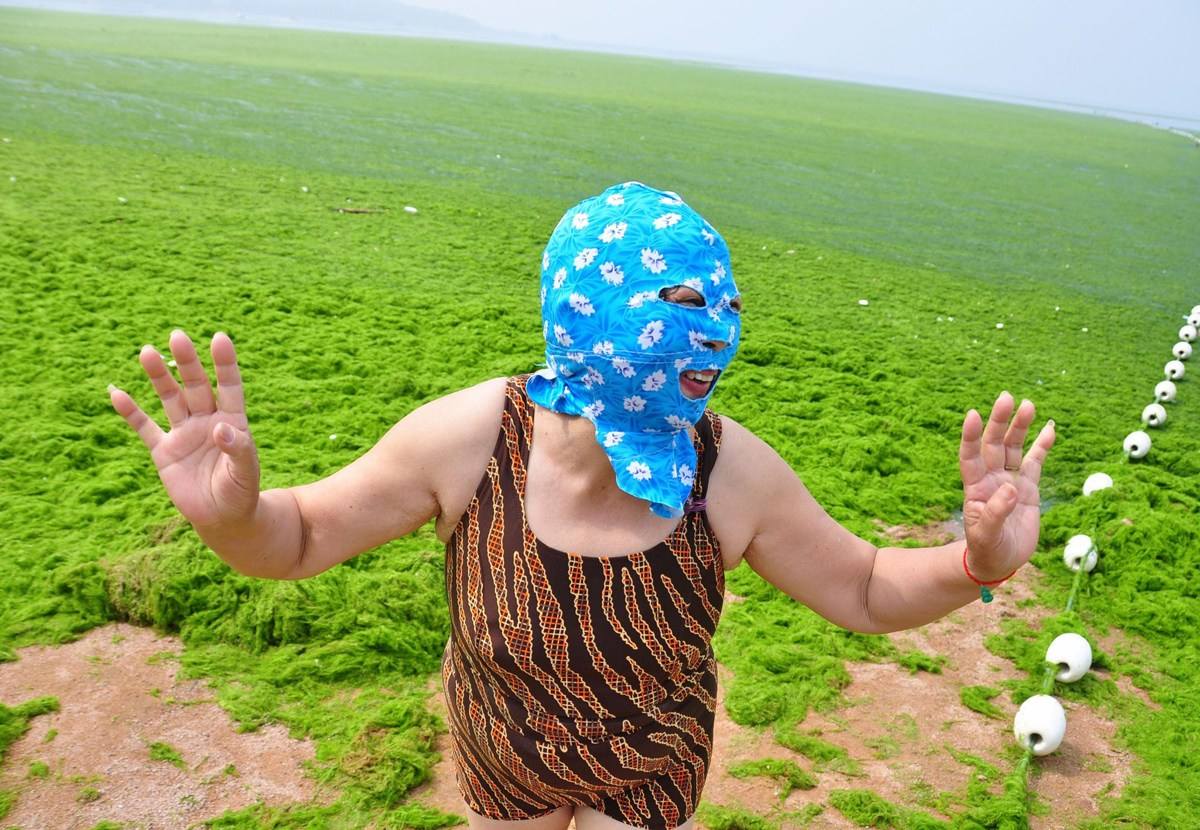 青島　マスクをかぶって海水浴をする女性