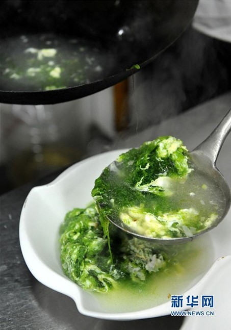 11日、藻と卵のスープを作る調理師。