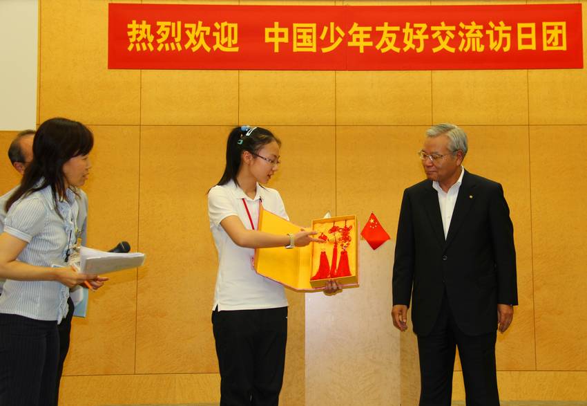 自ら作った「中国結」を京セラの久芳会長にプレゼントする中国の学生