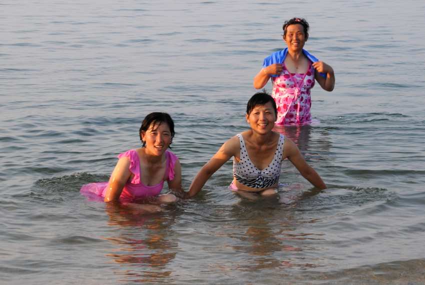 12日に撮影された、朝鮮東部海域の海水浴場で水遊びする朝鮮の女性。