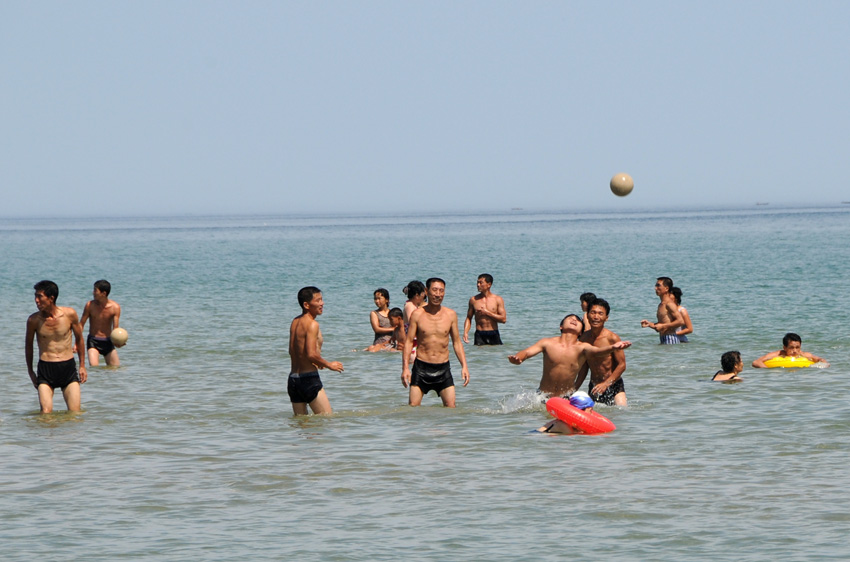 14日、朝鮮東部海域の海水浴場で、海でバレーボールをする青年たち。