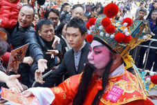 香港　「財神」が「福」の字の揮春を配って新春を祝う