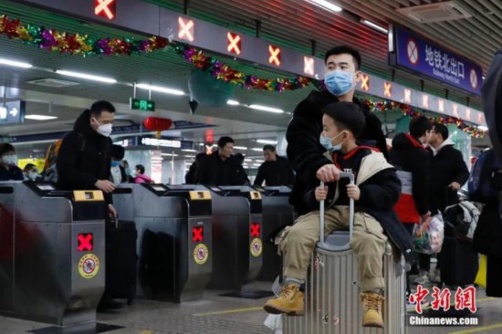 北京西駅でマスクを着用して改札口付近を移動する男性たち（資料写真、撮影・韓海丹）。