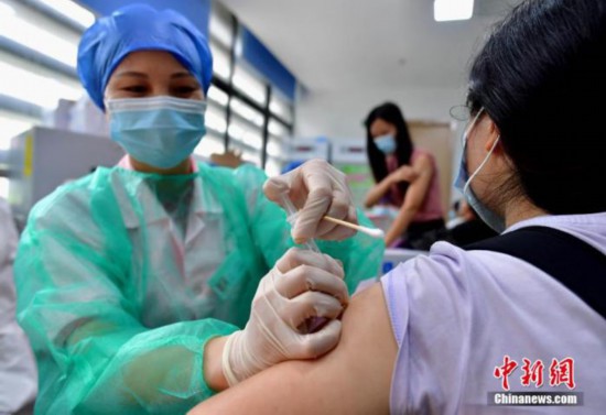 市民に新型コロナウイルスワクチンを接種する医療従事者（資料写真、撮影・張斌）。